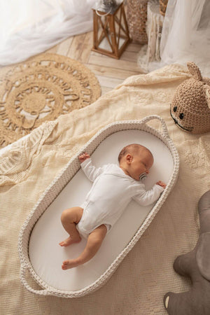 Crochet changing basket cream with a baby