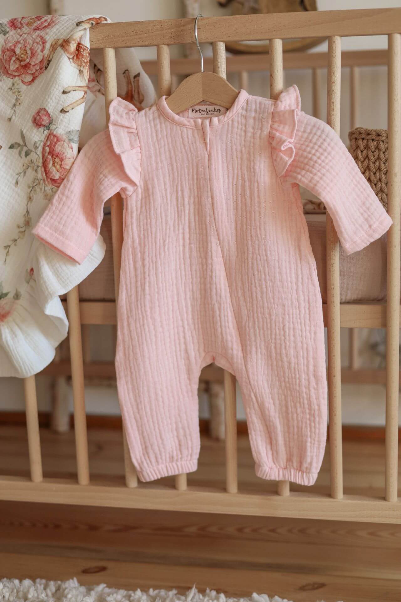 Měkký overal z organické bavlny GOTS, zapínání na zip - světle růžové s volánky (0-12 měsíců)
