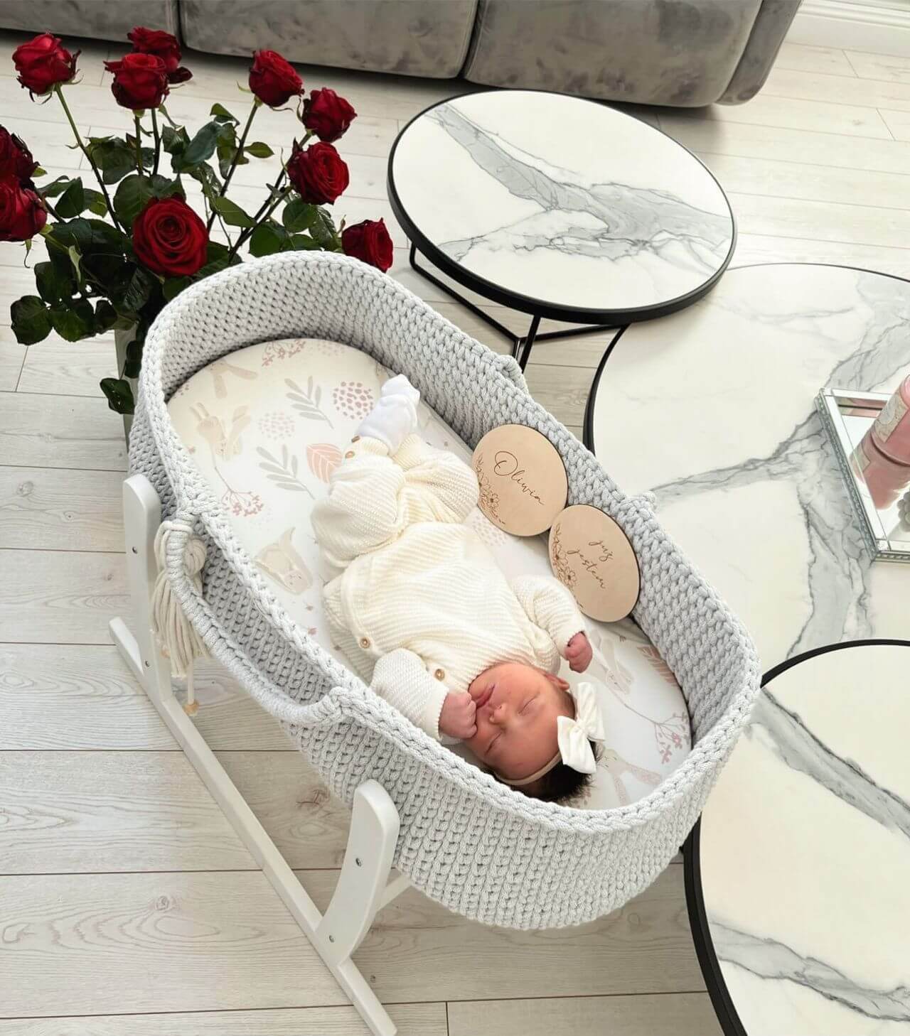 Grey handmade crochet moses basket with a sleeping baby 