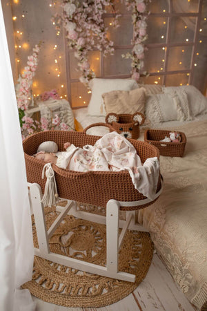 Baby sleeping in a chocolate brown handmade crochet moses basket