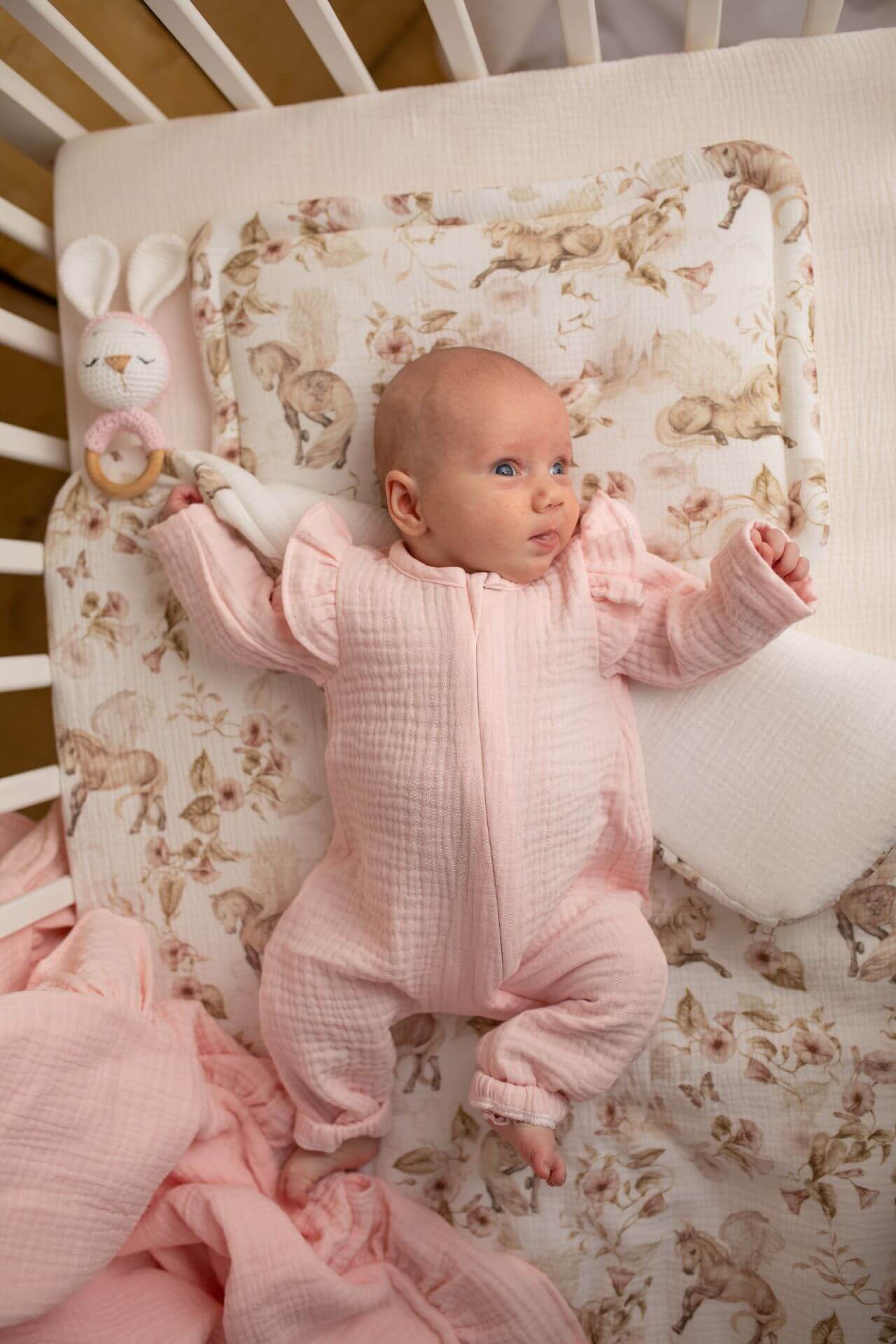 Měkký overal z organické bavlny GOTS, zapínání na zip - světle růžové s volánky (0-12 měsíců)